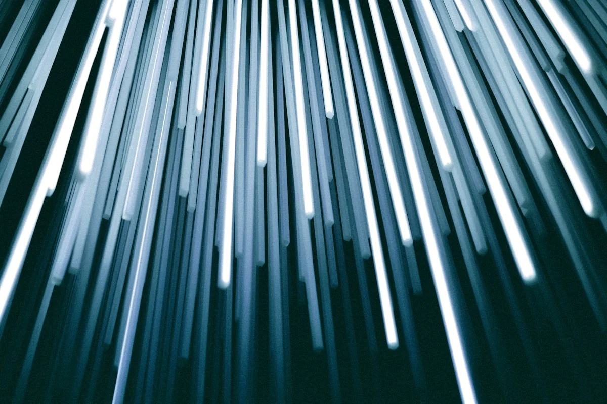 Fiber-optic tubes glowing in the dark, light gathered to a point.