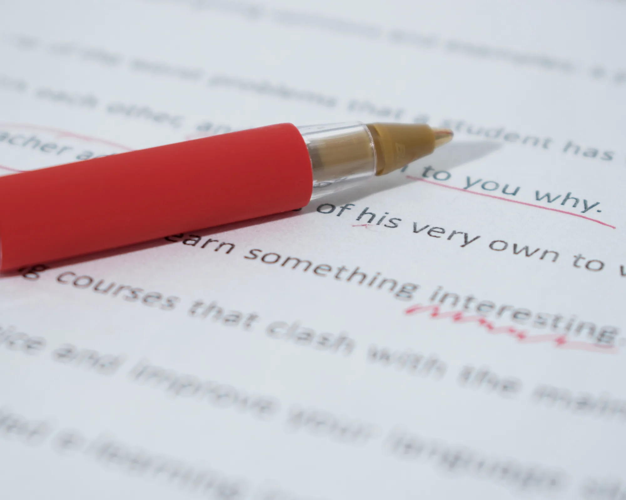 An academic coach marking a manuscript in red pen.
