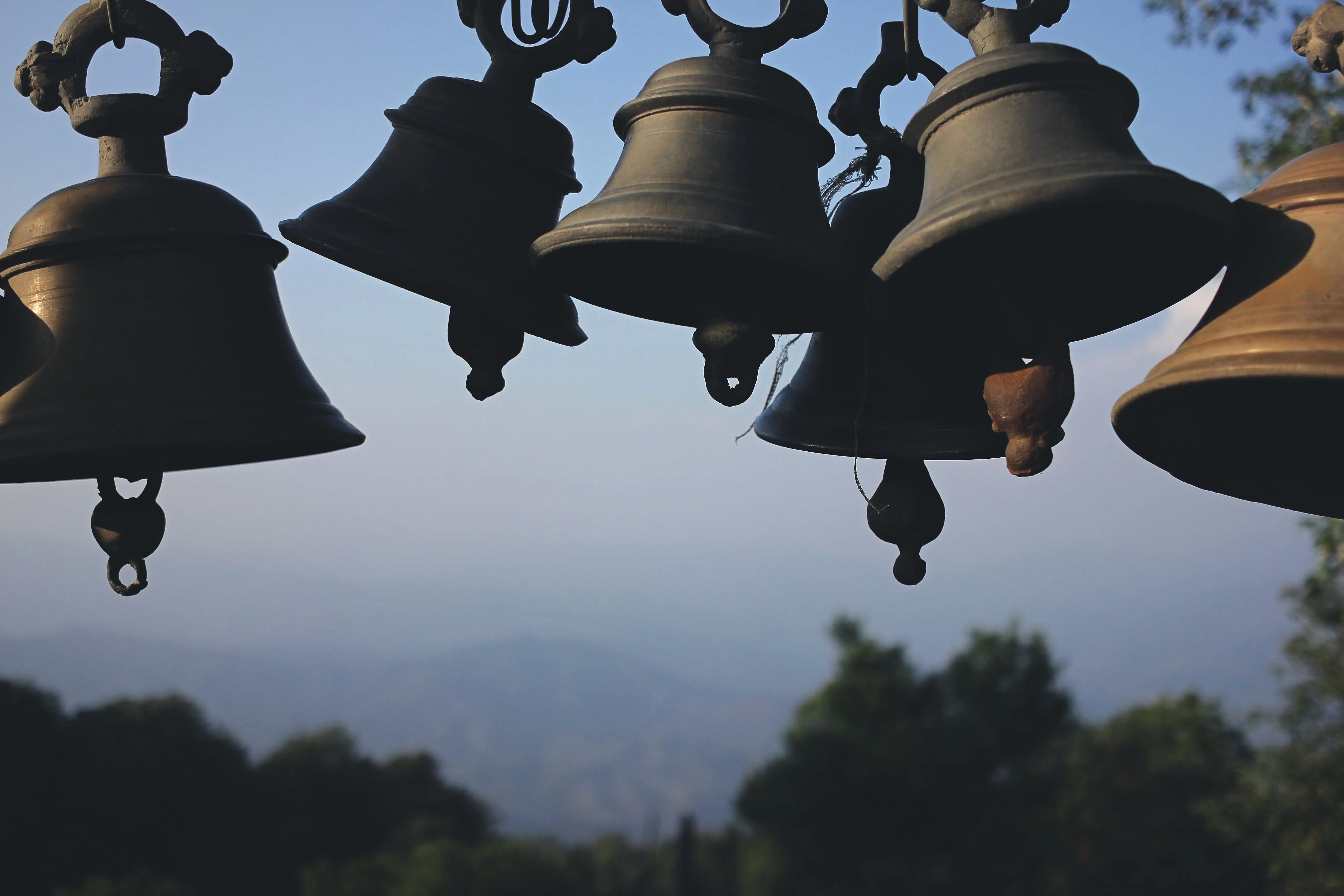 Rows of Tibetan bells hanging from a beam.
