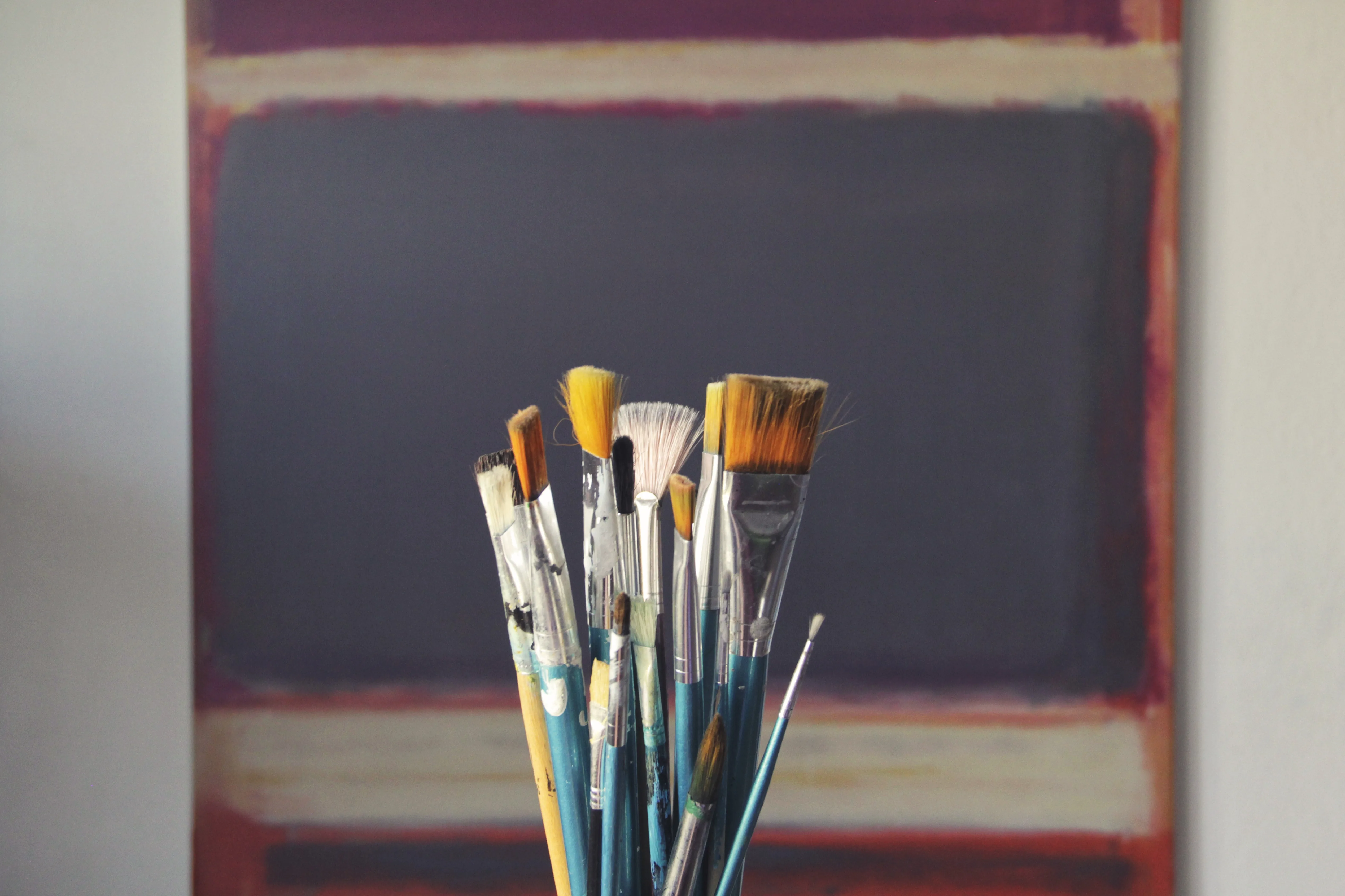 Paintbrushes upright in a jar, ready to be used.