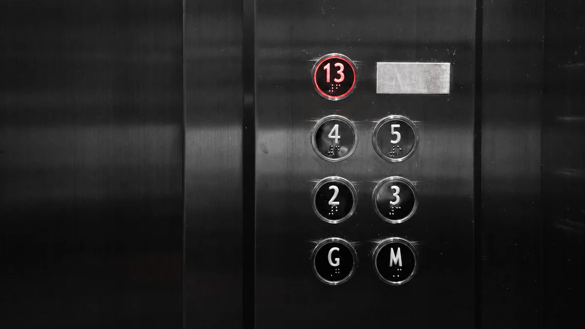 An elevator panel with the thirteenth floor lit.