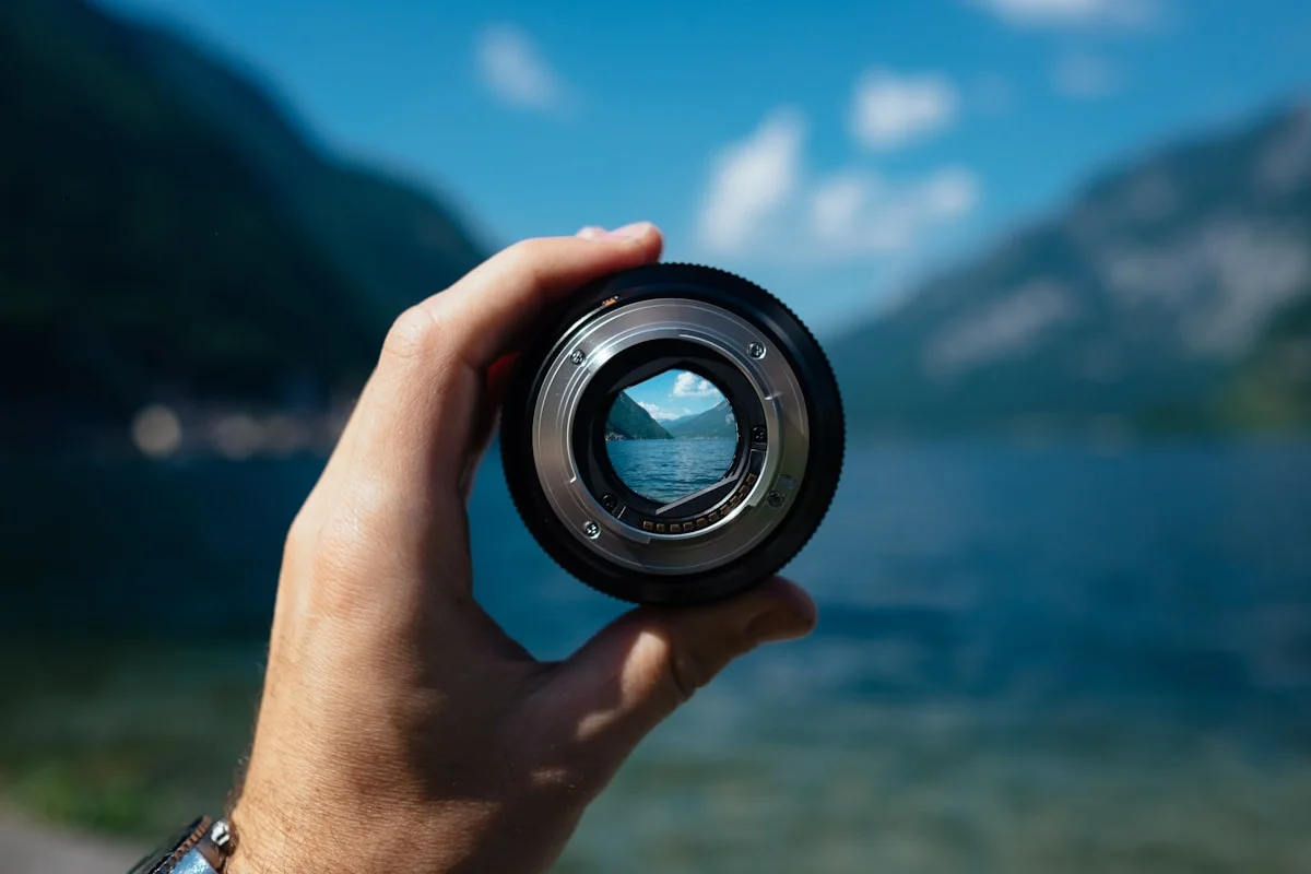 A mountain lake seen through a camera lens held up to the view.